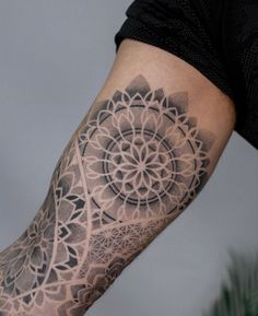 a man's arm with a tattoo on it that has an intricate flower design