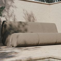 a couch sitting in front of a wall next to a pool