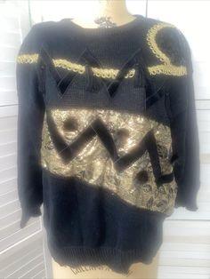 Vintage 80s Women's Sweater Bonnie and Bill by Holly Black Gold Glitter Sz Large This is it! Black knit ramie cotton blend (55/45). Light to medium weight shoulder pads. Long sleeves. The front has it all. Gold glitter ribbon lace. Tassels. Sequins. Velvet zig zag. Round puff balls. Gold lamée fabric. It's a mishmash of everything the 80s had. Hand wash. Good condition. Lightly worn only. No flaws to note. Measurements laying flat Pit to pit 23" Length 26" Waist 19" Sleeves shoulder seam to wrist 18" Puff Balls, 80s Women, Holly Black, Glitter Ribbon, Pullover Sweater Women, Black Knit, Women Pullover, Zig Zag, Shoulder Sleeve