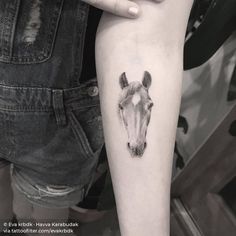 a horse head tattoo on the left inner arm