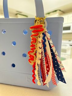 a blue bag with red, white and blue ribbons hanging from it's handles