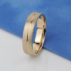 a gold wedding ring sitting on top of a blue cloth