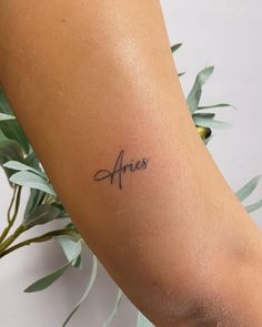 an arm tattoo with the word aris on it