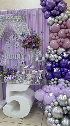 the table is set up with balloons, flowers and decorations for an elegant birthday party