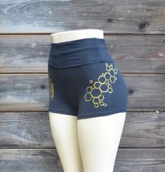 Honeybee Hot ShortsThese comfortable and stylish black  high waisted hot shorts feature a metallic gold honeybee design. The outside of the right leg is decorated with a screen print of my hand drawn sacred geometric honeybee image. They are finished off with a gold honeycomb on the outside of the left leg.All images were hand drawn and screened.Made in the USA95% Cotton / 5% SpandexAvailable in sizes:SMALL, MEDIUM, LARGE and X-LARGEPlease check out my Instagram @UriahClearLight to learn more ab Gold Stretch Short Bottoms, Fitted Gold Shorts For Summer, Gold Stretch Bottoms Short Length, Gold Fitted Bottoms Short Length, Fitted Gold Shorts, Fitted Gold Bottoms Short Length, Gold Fitted Short Bottoms, Honeybee Design, Sacred Geometric