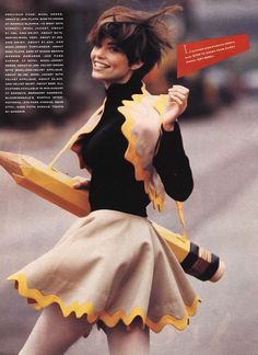 a woman is walking down the street in a skirt and jacket with scalloped edges