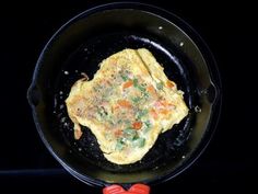 an omelet is being cooked in a skillet on top of the stove