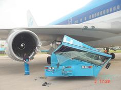 an airplane is being loaded with luggage by a man in blue overalls and safety gear