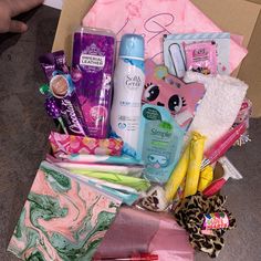 a box filled with personal care products and toiletries next to a pile of other items