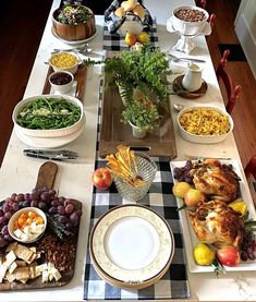 a long table is set with many plates and bowls full of food, including turkey