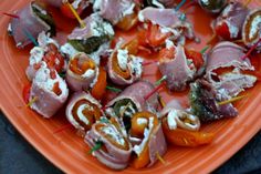 an orange plate topped with meat and veggies on skewered toothpicks