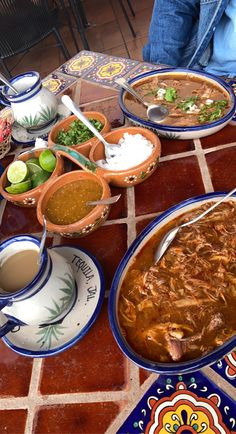 a table topped with bowls and plates filled with different types of food on top of it