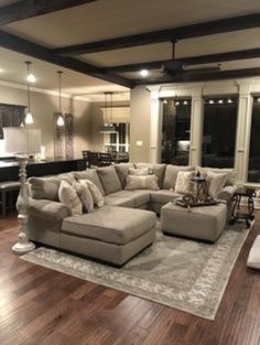 a living room filled with lots of furniture on top of a hard wood floored floor