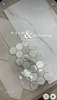 a white marble tile with the words warm and welcoming on it's front cover