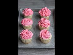 cupcakes with pink frosting on a metal tray