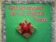 a green sign that says get wrapped up in a good book with a red bow on it