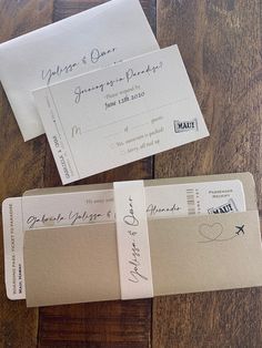 two envelopes with some writing on them sitting on a wooden table next to each other