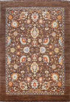 a brown rug with an intricate design on the center and sides, in various colors