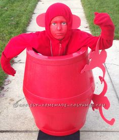 a man dressed as a red devil in a barrel costume