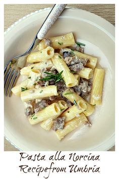 a white plate topped with pasta and meat