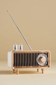 an old fashioned radio sitting on top of a wooden table next to two glasses and a toothbrush