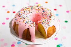 a bundt cake with pink icing and sprinkles on a plate