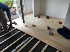 a man standing on top of a hard wood floor next to a window and tools