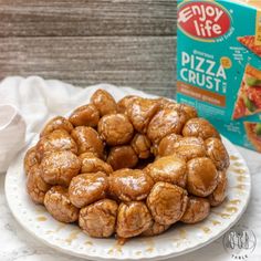 a white plate topped with doughnuts next to a carton of pizza crust