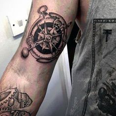 a man with a compass tattoo on his arm