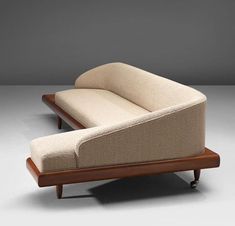 a beige couch sitting on top of a wooden frame