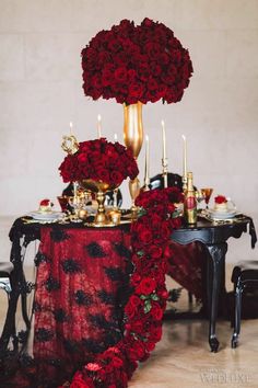 a table topped with red roses and candles