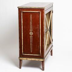 an old wooden cabinet with painted designs on the front and sides, against a white background