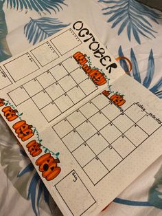 a calendar with pumpkins on it sitting on a bed