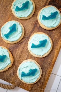 cookies with blue frosting on a wooden board