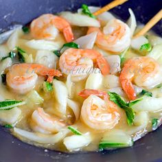 shrimp and cabbage stir fry in a wok with chopsticks