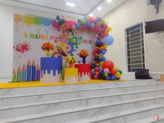 there are many balloons and decorations on the steps in front of this stage set up