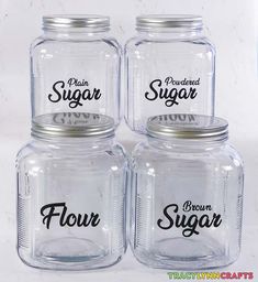 four glass jars with the words flour, sugar and brown sugar written on each jar