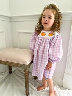 Be the talk of the pumpkin patch with this fun purple gingham pumpkin smocked dress!  Clothing Care Instructions: Machine wash gentle. Do not bleach. Tumble dry delicate at low heat. Iron at medium. If the item that you are ordering has red or another bright color in it next to a white or other light color fabric please use a Shout color catcher for the first few washes to avoid bleeding.  Follow us on Instagram @thelillieandlilahshop for shop discounts and updates! Fall Cotton Smocked Back Dress, Fall Cotton Smocked Dress, Pink Smocked Bodice Dress For Fall, Fall Smocked Dress For Daywear, Cute Daywear Dresses For Fall, Plaid Cotton Smocked Dress, Cute Dresses For Daywear In Fall, Cute Cotton Smocked Dress In Gingham, Cute Gingham Smocked Cotton Dress