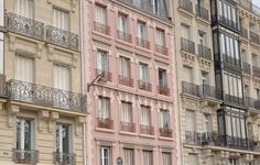 several different colored buildings with balconies and windows