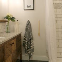 a bathroom with a sink, mirror and bathtub next to a wooden cabinet in the corner