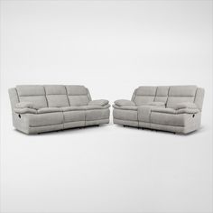 two reclining sofas sitting next to each other on a white surface with no one in it