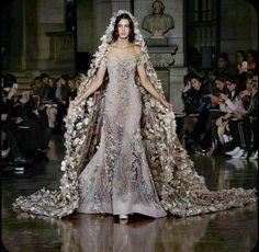 a model walks down the runway in an elaborate gown