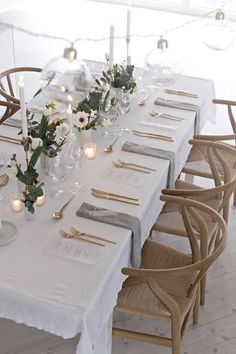 a long table is set with candles and place settings for dinner guests to sit at