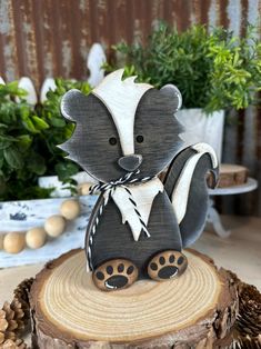 a wood carving of a raccoon sitting on top of a tree stump with pine cones around it