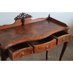 an old wooden desk with drawers on the bottom and one drawer open to show what's inside