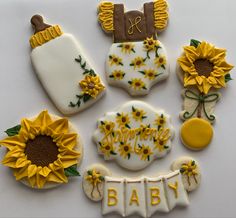 decorated cookies with sunflowers and baby's names are arranged on a white surface