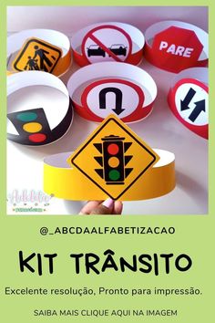 a person holding up a sign that says kit transito in spanish and has various traffic signs on it