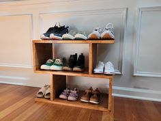 there are many pairs of shoes on the shelves in this room with wood floors and white walls