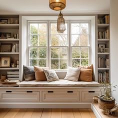 a window seat in the corner of a room with bookshelves on either side