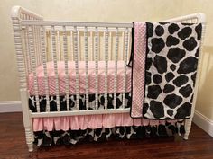 a white crib with pink and black bedding